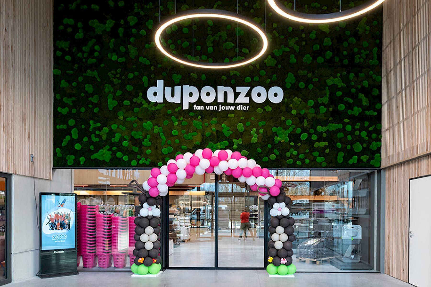De ingang van de winkel van Duponzoo, feestelijk versierd met witte en roze ballonen.